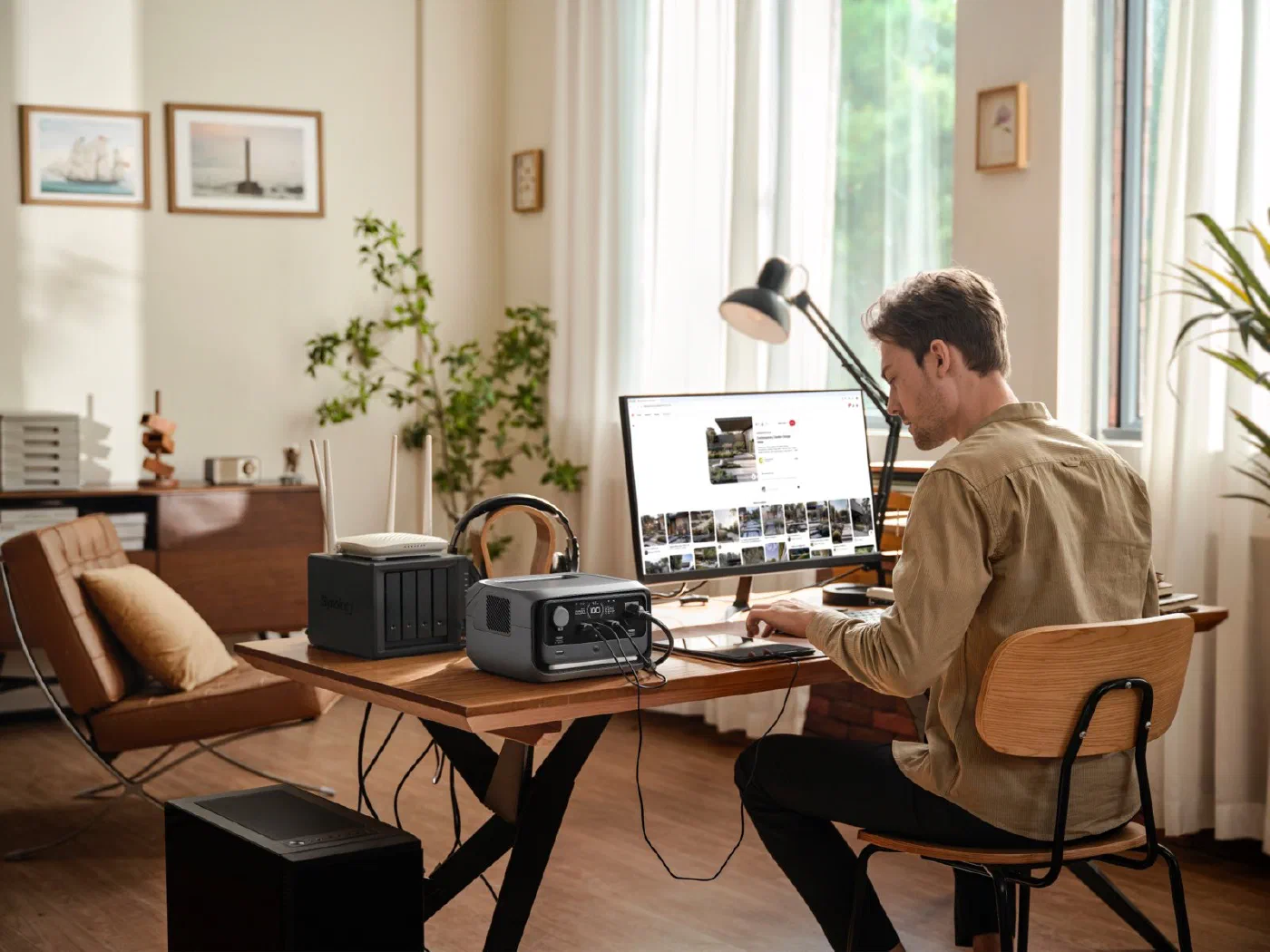 EcoFlow River 3 Plus sobre uma mesa de escritório, ligada ao lado de um NAS e de um roteador